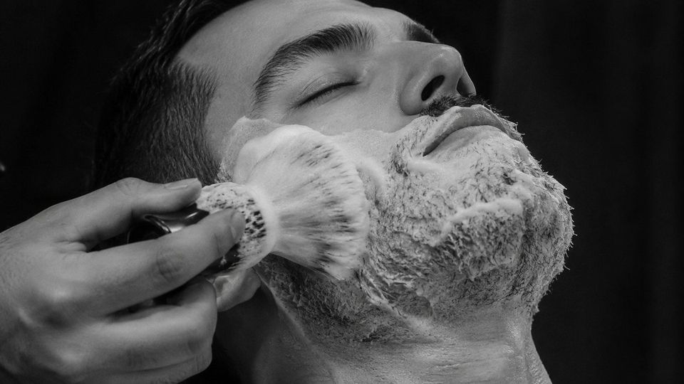 Lather brushed onto a client's beard