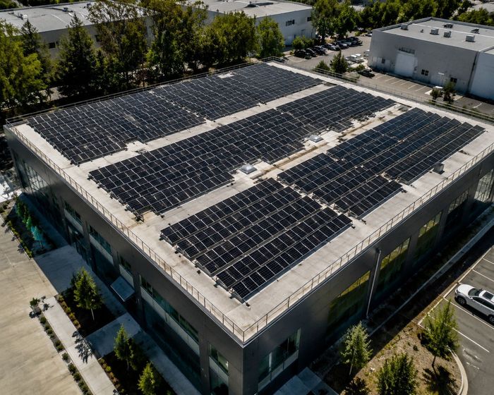 Rows of commercial solar panels on a large flat rooftop array