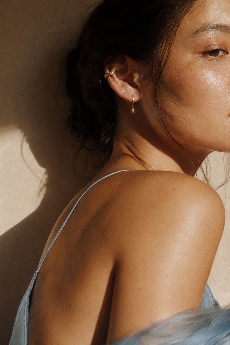 Hook earring worn with a plain cuff on the shoulder