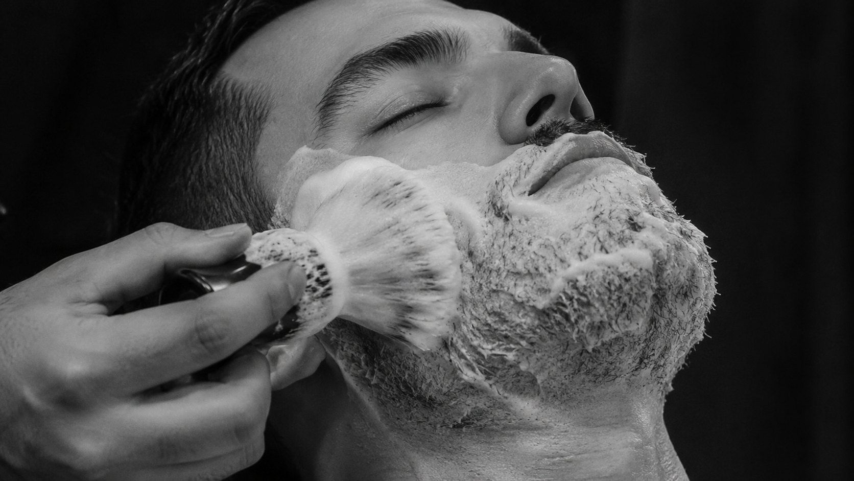 Lather brushed onto a client's beard
